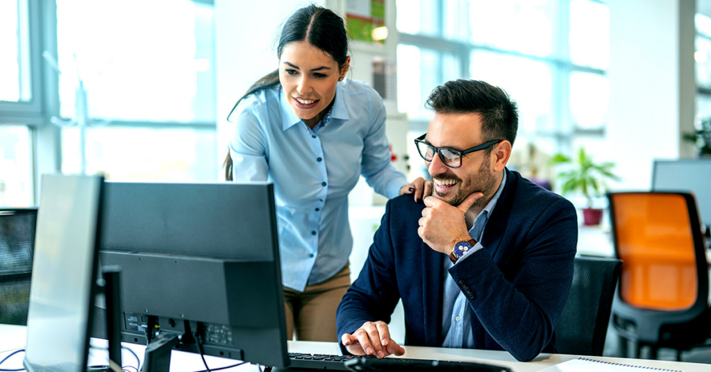 Two people collaborating looking at a computer screen