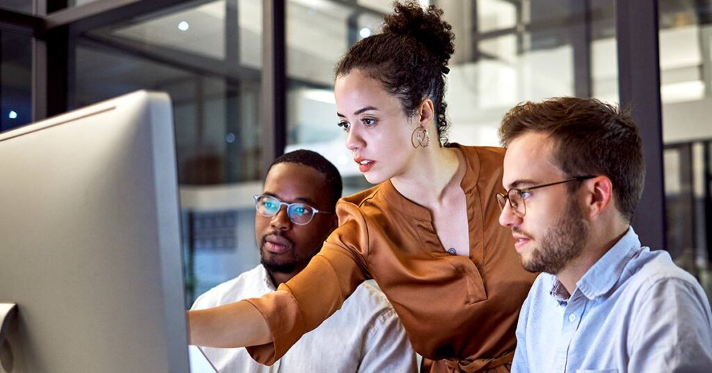 Group of professionals collaborating in front of a computer